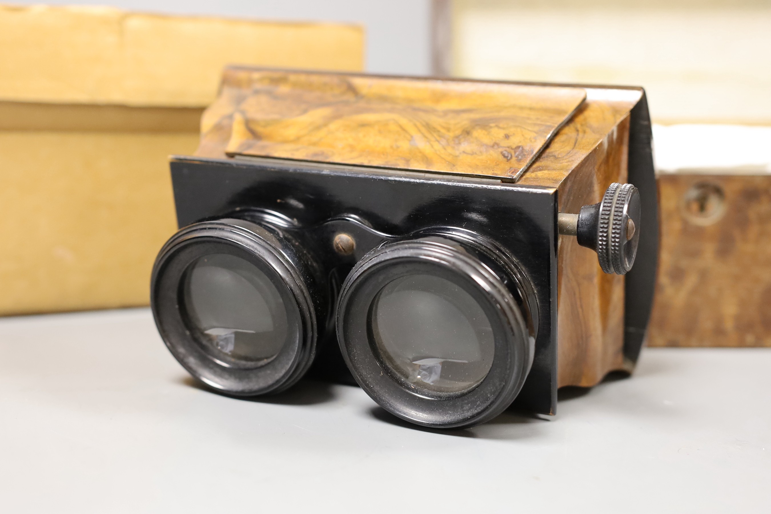 A Victorian walnut stereoscopic viewer and a quantity of slides